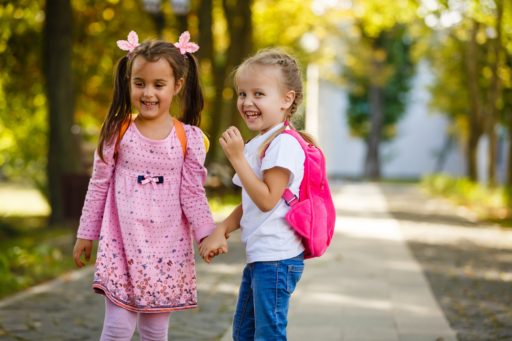 Deux jeunes filles avec le sourire au moment d'aller à l'école. Elles se tiennent la main